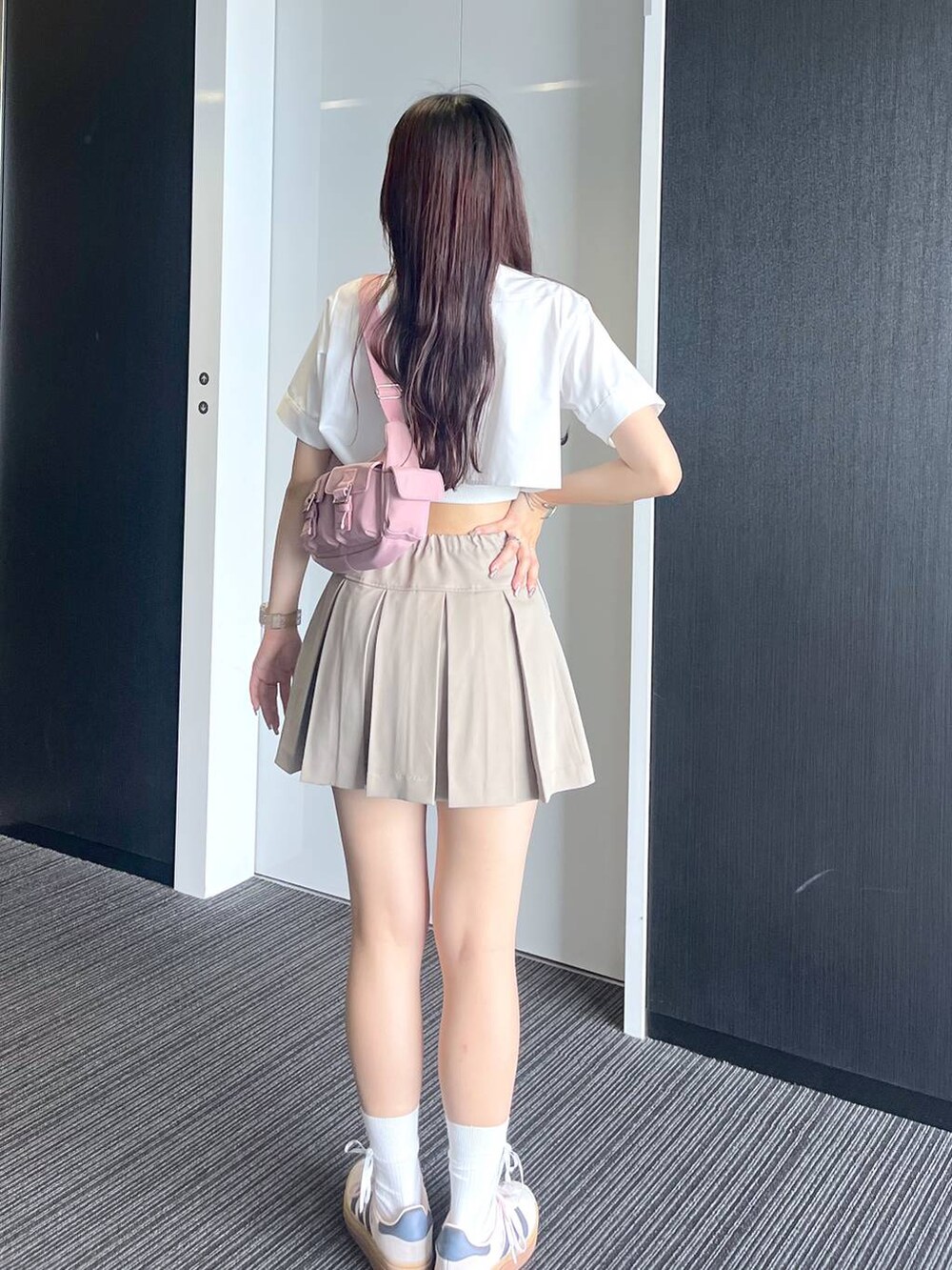 ピンク系のショルダーバッグ、ホワイト系のキャミソール、ベージュ系のスカートを着用したレディースの夏コーディネートの5枚目の写真