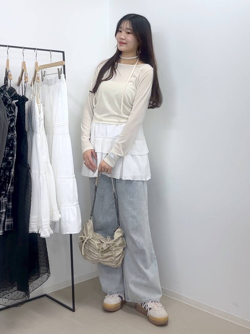 ホワイト系のキャミソール、ブルー系のデニムパンツ、ホワイト系のスカートを着用したレディースの春コーディネートの5枚目の写真