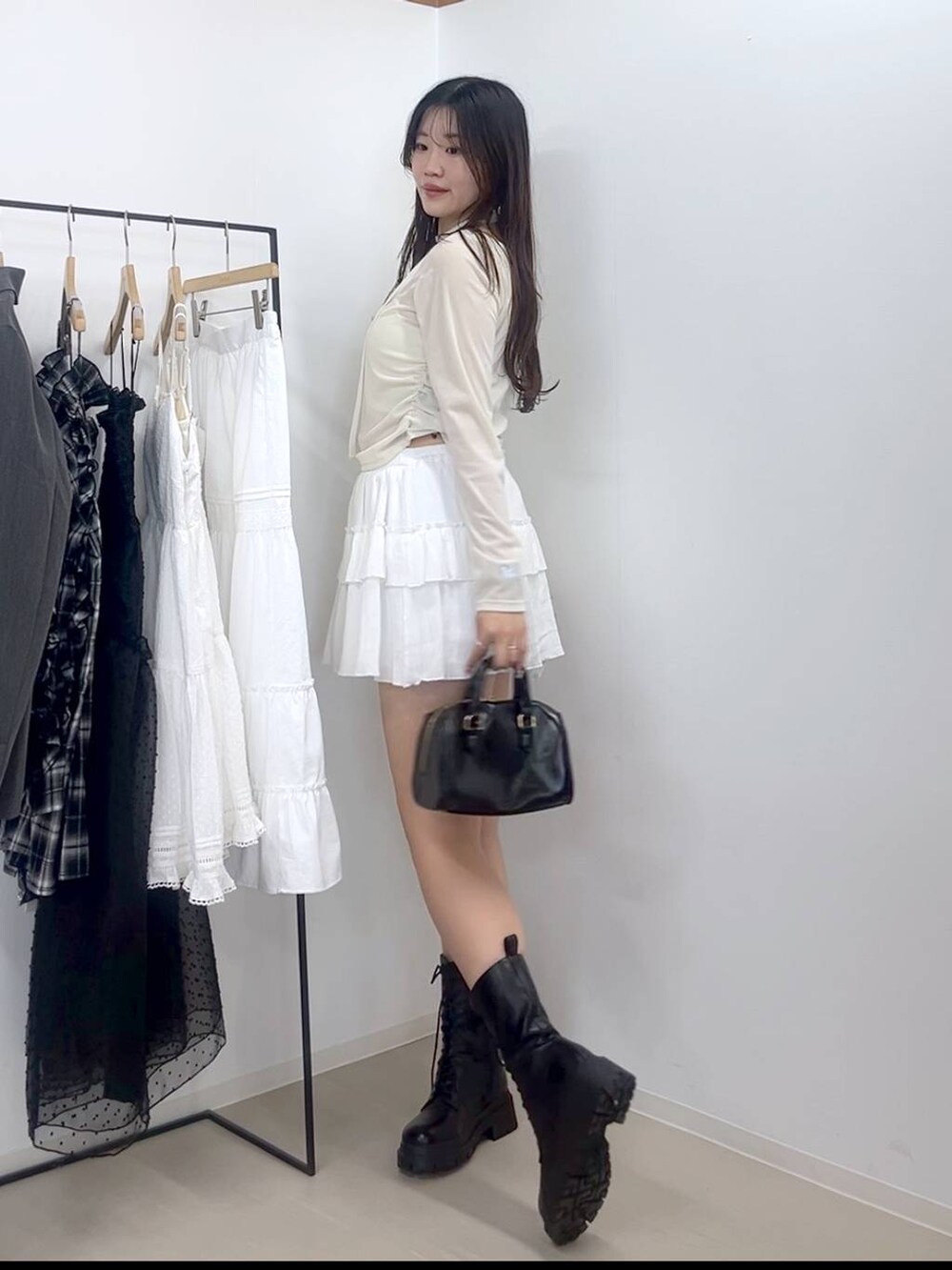 ホワイト系のキャミソール、ホワイト系のスカート、ブラック系のブーツを着用したレディースの春コーディネートの4枚目の写真