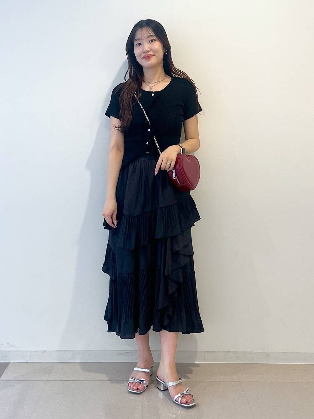 ホワイト系のキャミソール、ブラック系のスカート、シルバー系のサンダルを着用したレディースの春コーディネートの10枚目の写真