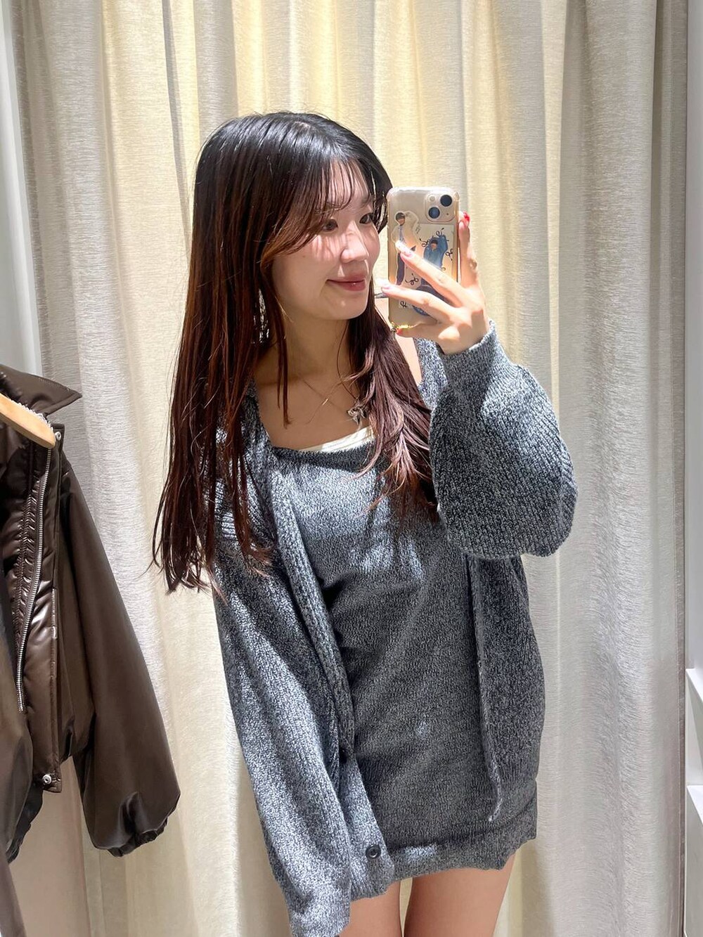 ブラウン系のショルダーバッグ、ブラック系のブーツ、ホワイト系のTシャツ/カットソーを着用したレディースの冬コーディネートの2枚目の写真