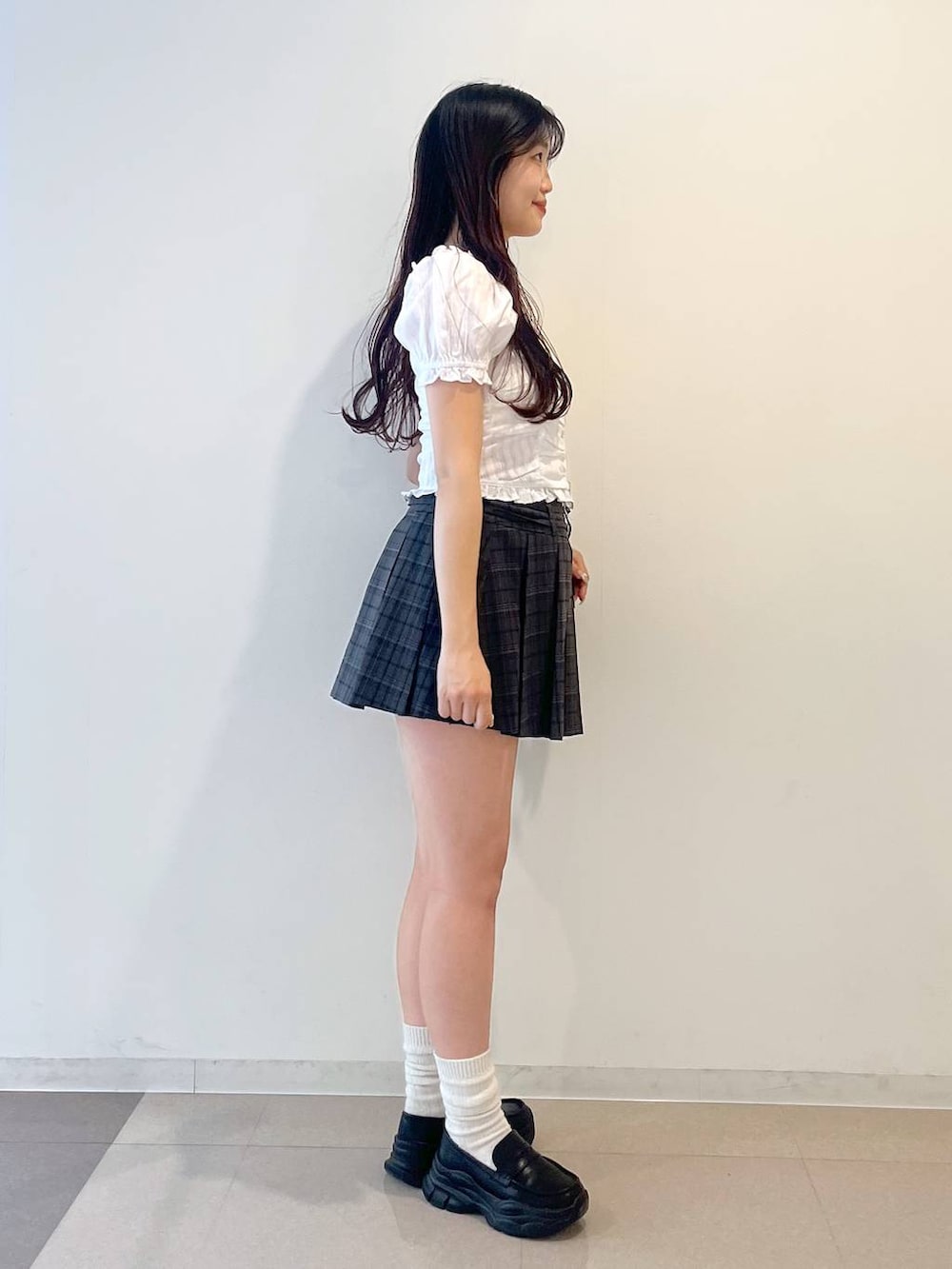 ホワイト系のキャミソール、ブラック系のローファー、グレー系のスカートを着用したレディースの春コーディネートの5枚目の写真