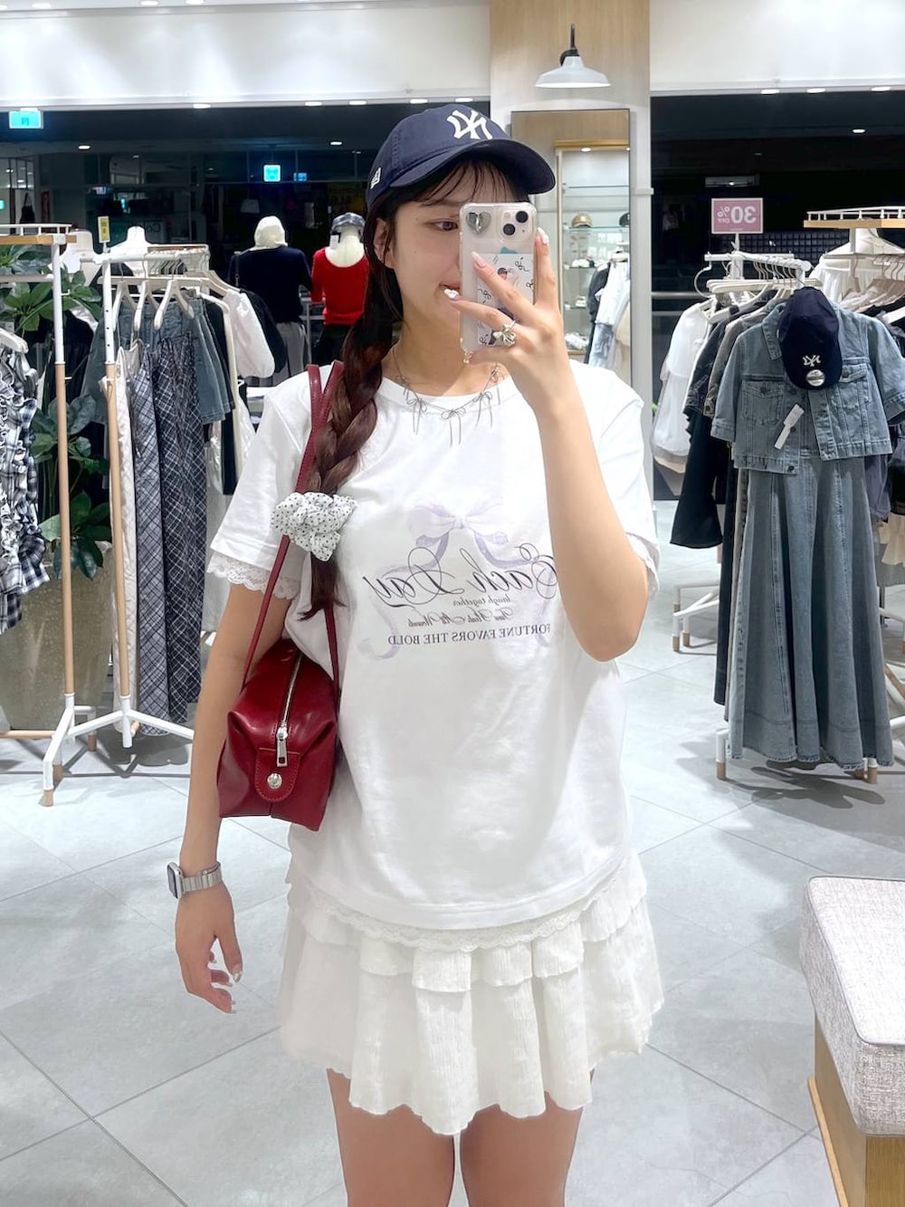 ホワイト系のキャミソール、ホワイト系のスカート、レッド系のボストンバッグを着用したレディースの春コーディネートの2枚目の写真