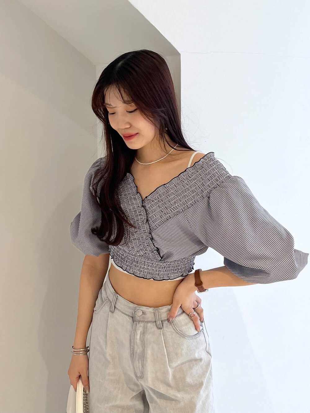 シルバー系のサンダル、ホワイト系のキャミソール、グレー系のデニムパンツを着用したレディースの夏コーディネートの3枚目の写真