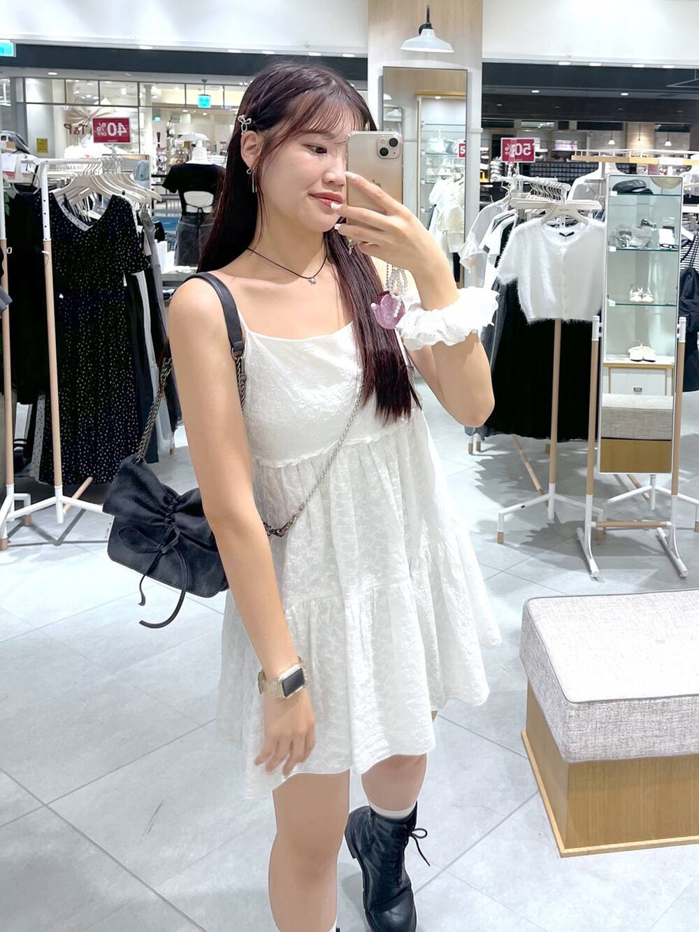 グレー系のショルダーバッグ、ホワイト系のワンピース、ブラック系のブーツを着用したレディースの夏コーディネートの6枚目の写真