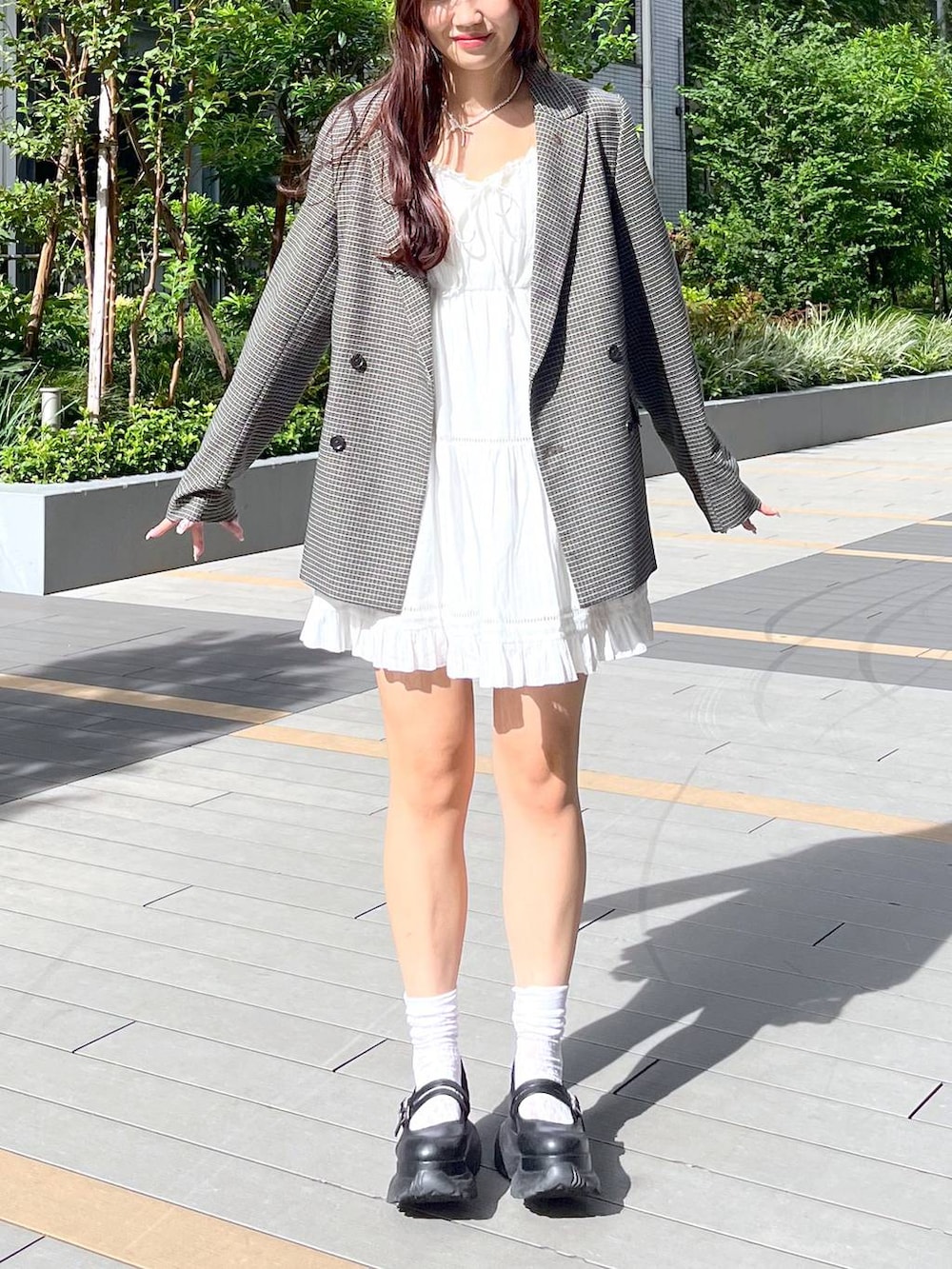 ホワイト系のキャミソール、ホワイト系のワンピース、ブラック系のスニーカーを着用したレディースの秋コーディネートの4枚目の写真