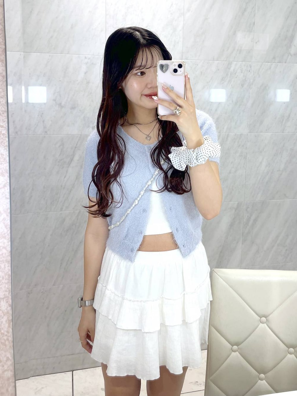 ホワイト系のキャミソール、ホワイト系のスカート、ブルー系のカーディガン/ボレロを着用したレディースの春コーディネートの2枚目の写真