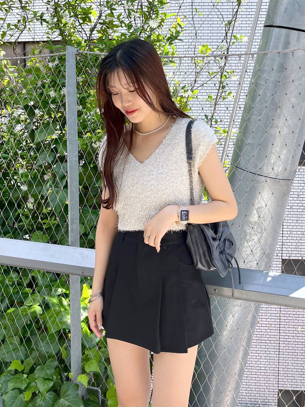 ブラック系のスカート、ホワイト系のキャミソール、ホワイト系のサンダルを着用したレディースの夏コーディネートの6枚目の写真