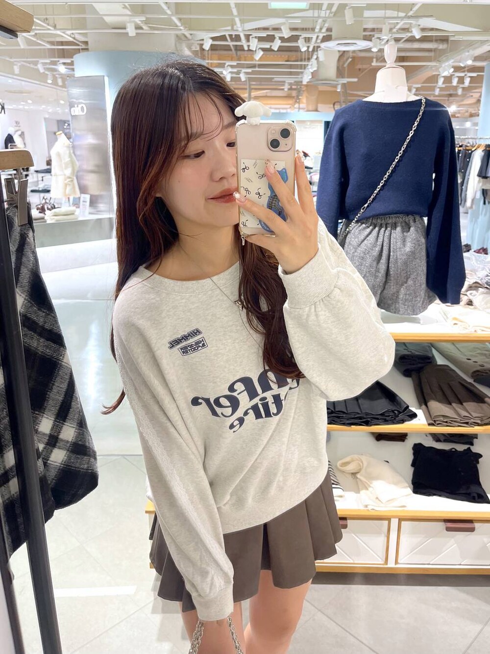 ホワイト系のTシャツ/カットソー、ブラウン系のスカート、ベージュ系のブーツを着用したレディースの秋コーディネートの5枚目の写真