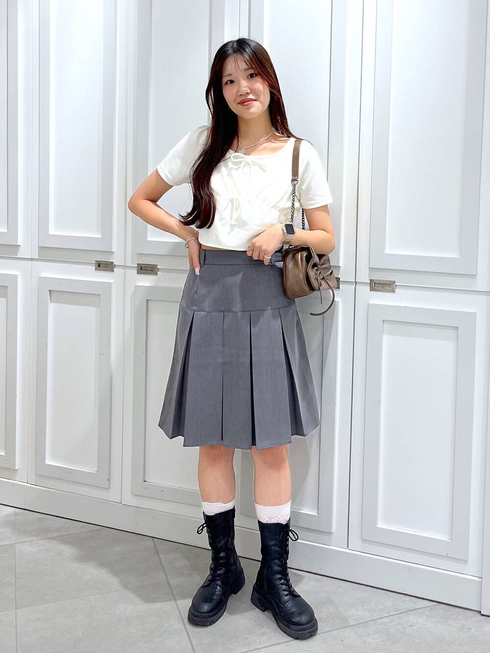 ブラウン系のショルダーバッグ、グレー系のスカート、ホワイト系のキャミソールを着用したレディースの夏コーディネートの3枚目の写真