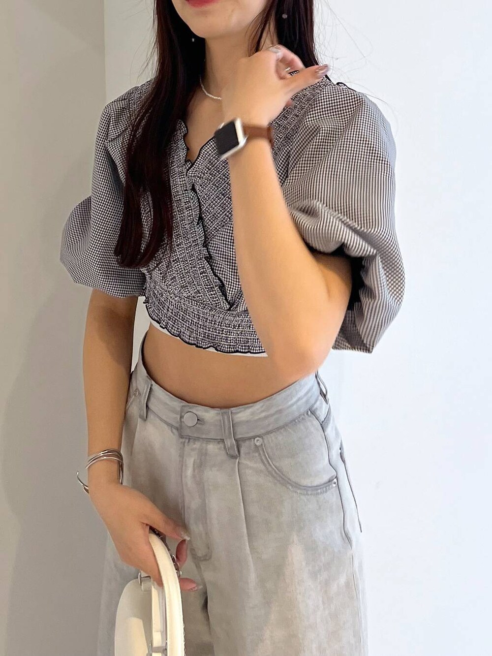 シルバー系のサンダル、ホワイト系のキャミソール、グレー系のデニムパンツを着用したレディースの春コーディネートの5枚目の写真