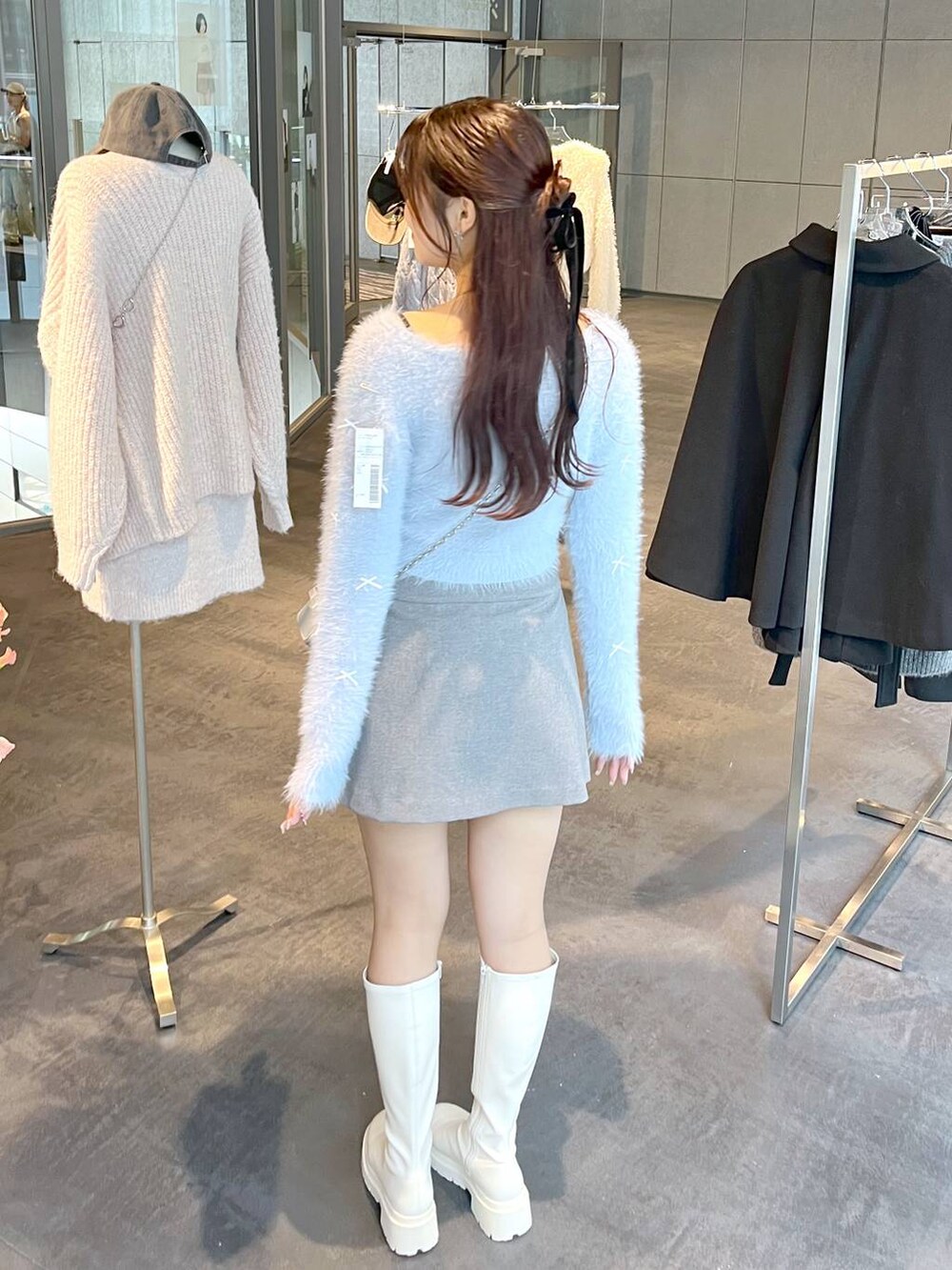 グレー系のスカート、ホワイト系のブーツ、ホワイト系のTシャツ/カットソーを着用したレディースの秋コーディネートの3枚目の写真