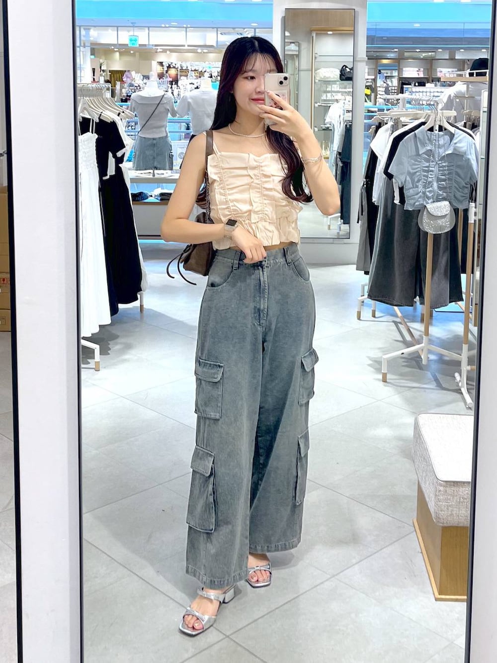 シルバー系のサンダル、ホワイト系のキャミソール、ブルー系のデニムパンツを着用したレディースの夏コーディネートの2枚目の写真