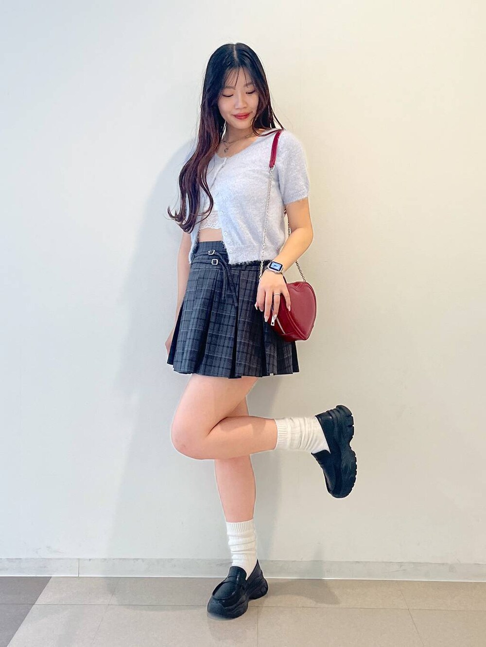 ブラック系のローファー、グレー系のスカート、レッド系のショルダーバッグを着用したレディースの春コーディネートの6枚目の写真