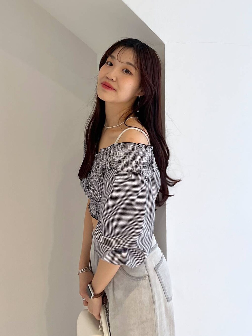 シルバー系のサンダル、ホワイト系のキャミソール、グレー系のデニムパンツを着用したレディースの夏コーディネートの9枚目の写真