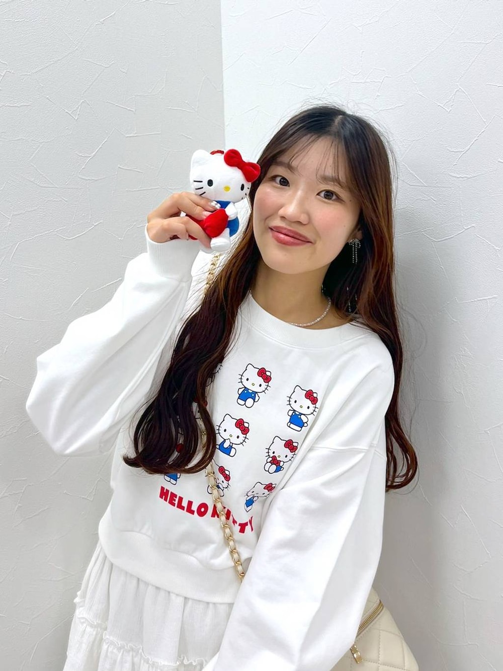 ホワイト系のTシャツ/カットソー、ホワイト系のショルダーバッグ、ホワイト系のブーツを着用したレディースの秋コーディネートの4枚目の写真