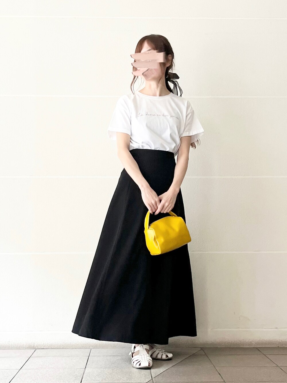 ホワイト系のTシャツ/カットソー、イエロー系のハンドバッグ、ブラック系のスカートを着用したレディースの春コーディネートの5枚目の写真