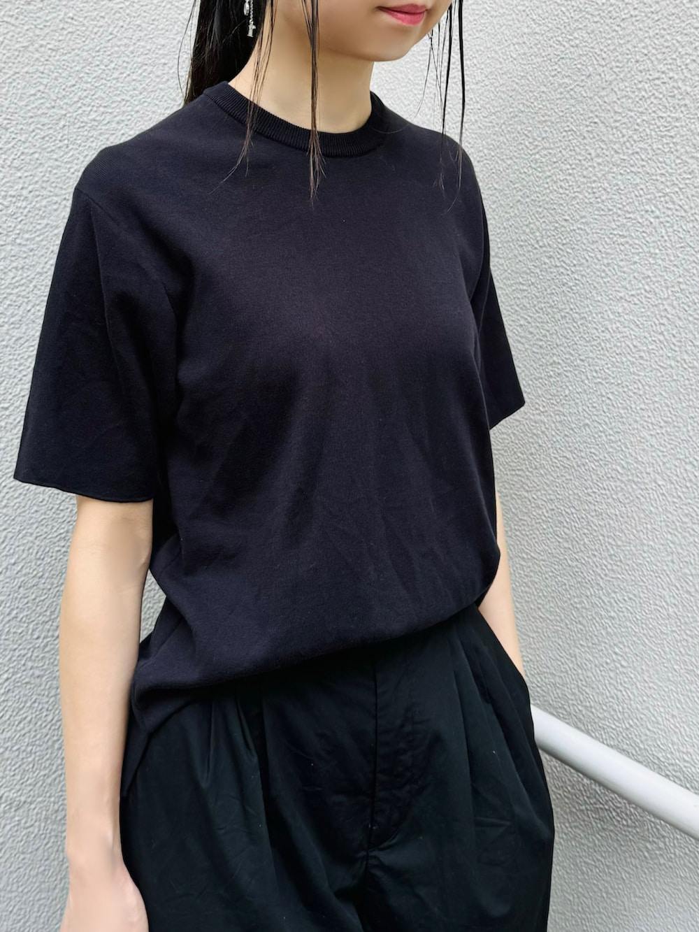 ブラック系のシューズ、ブラック系のトートバッグ、ブラック系のパンツを着用したレディースの夏コーディネートの3枚目の写真