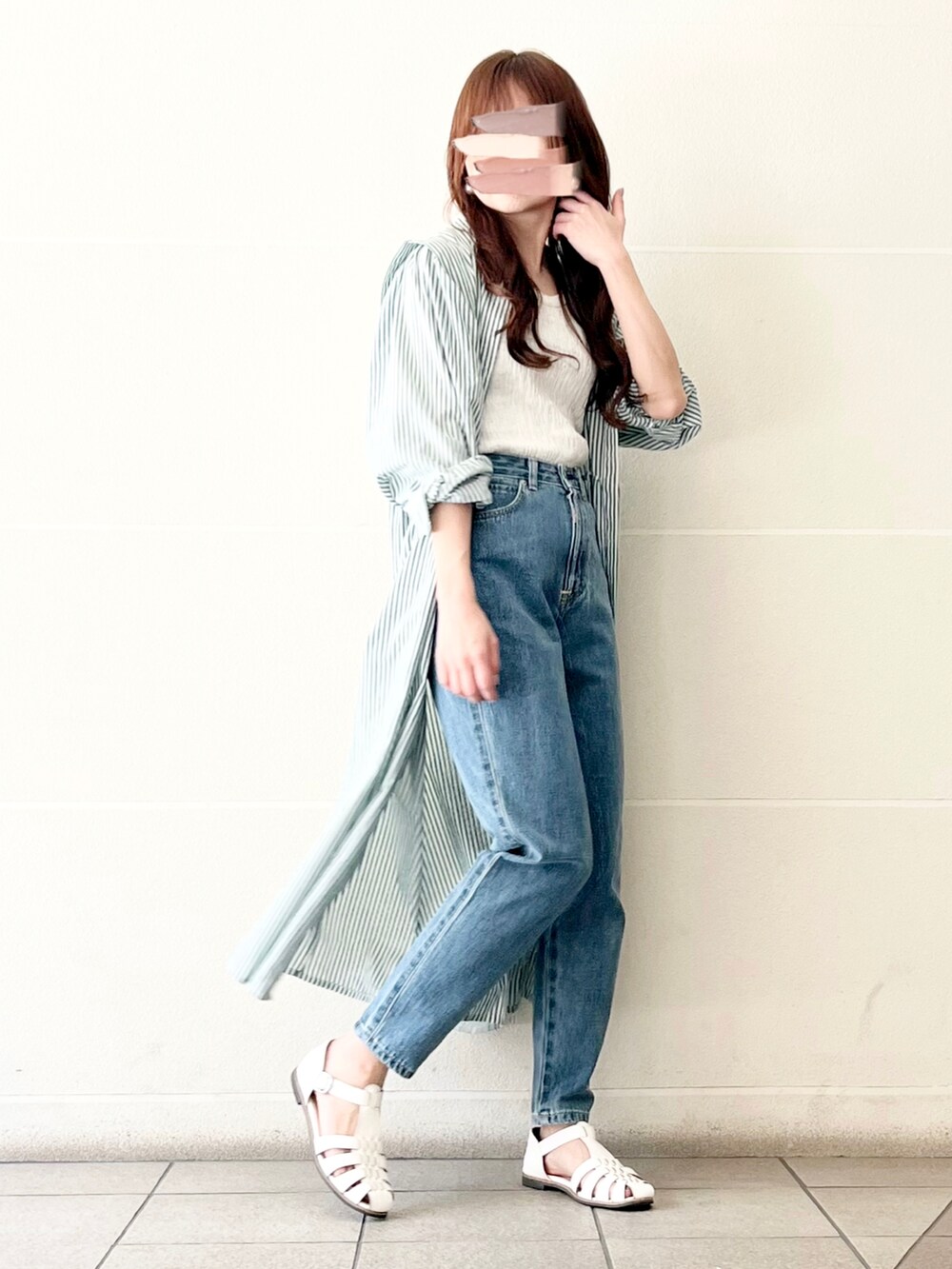 ブルー系のデニムパンツ、ホワイト系のタンクトップ、グリーン系のワンピースを着用したレディースの春コーディネートの5枚目の写真