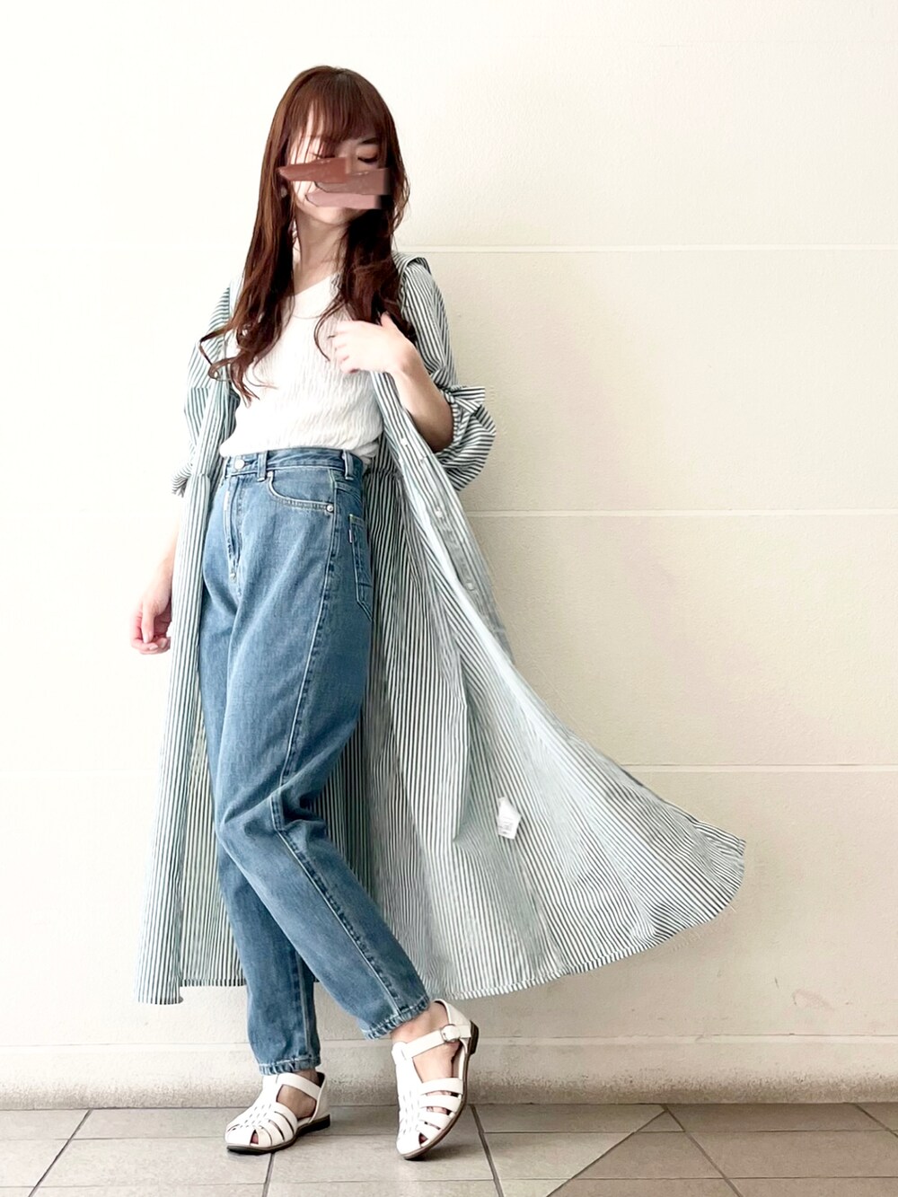 ブルー系のデニムパンツ、ホワイト系のタンクトップ、グリーン系のワンピースを着用したレディースの春コーディネートの3枚目の写真
