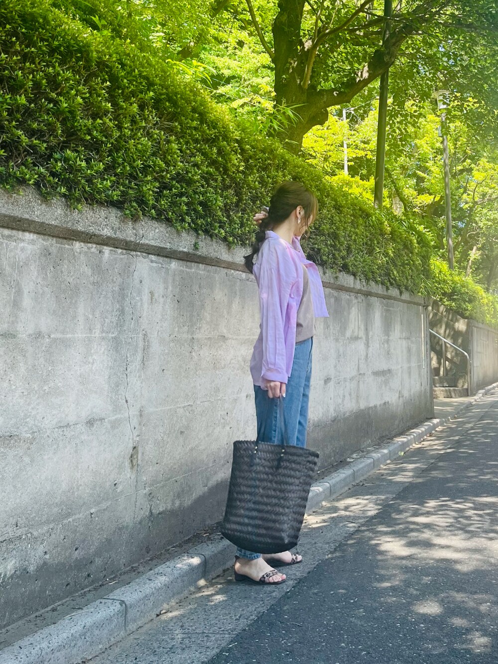 ブルー系のデニムパンツ、ブラウン系のニット/セーター、ピンク系のシャツ/ブラウスを着用したレディースの夏コーディネートの3枚目の写真