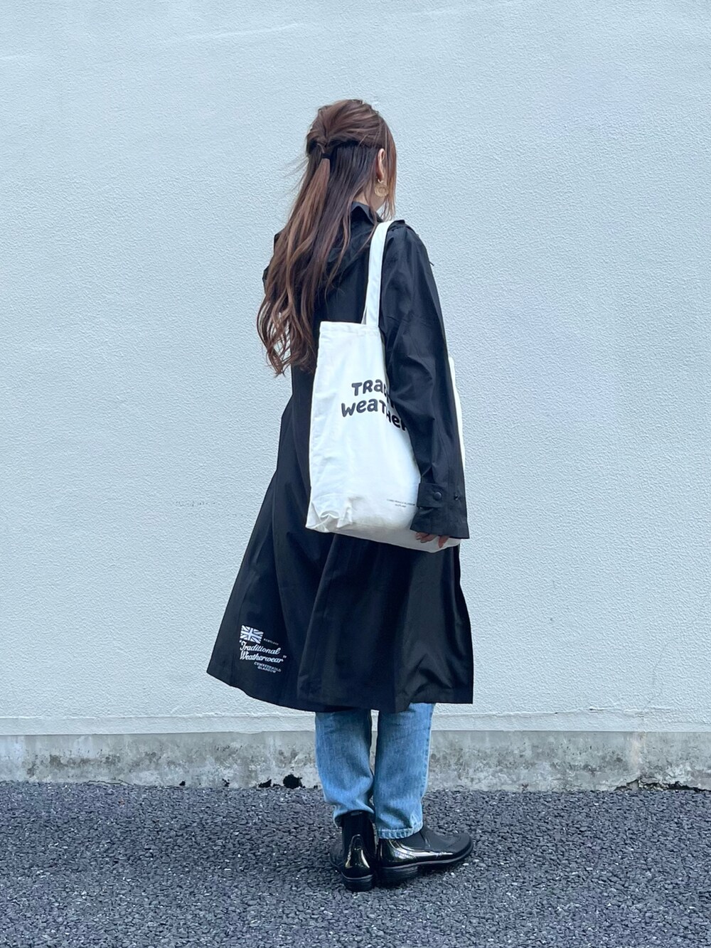 ブラック系のレインシューズ、ホワイト系のトートバッグ、ブルー系のデニムパンツを着用したレディースの夏コーディネートの4枚目の写真