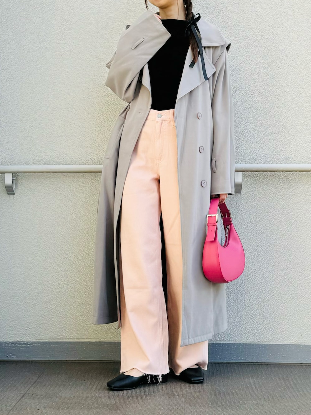 ブラック系のパンプス、グレー系のトレンチコート、ピンク系のハンドバッグを着用したレディースの春コーディネートの3枚目の写真