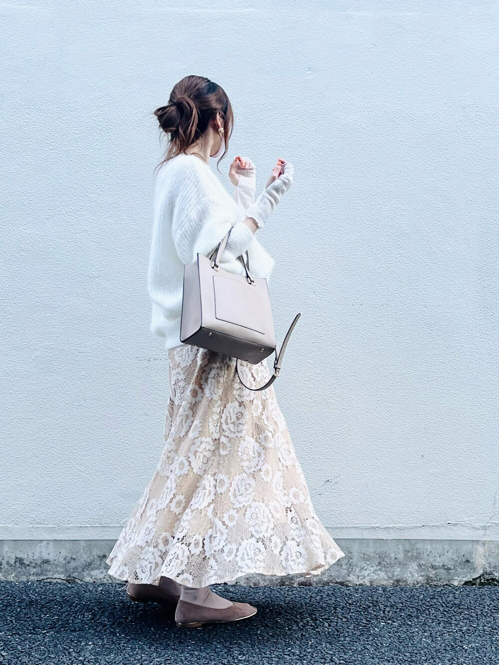 ベージュ系のスカート、ホワイト系のニット/セーター、ベージュ系のバッグを着用したレディースの春コーディネートの4枚目の写真