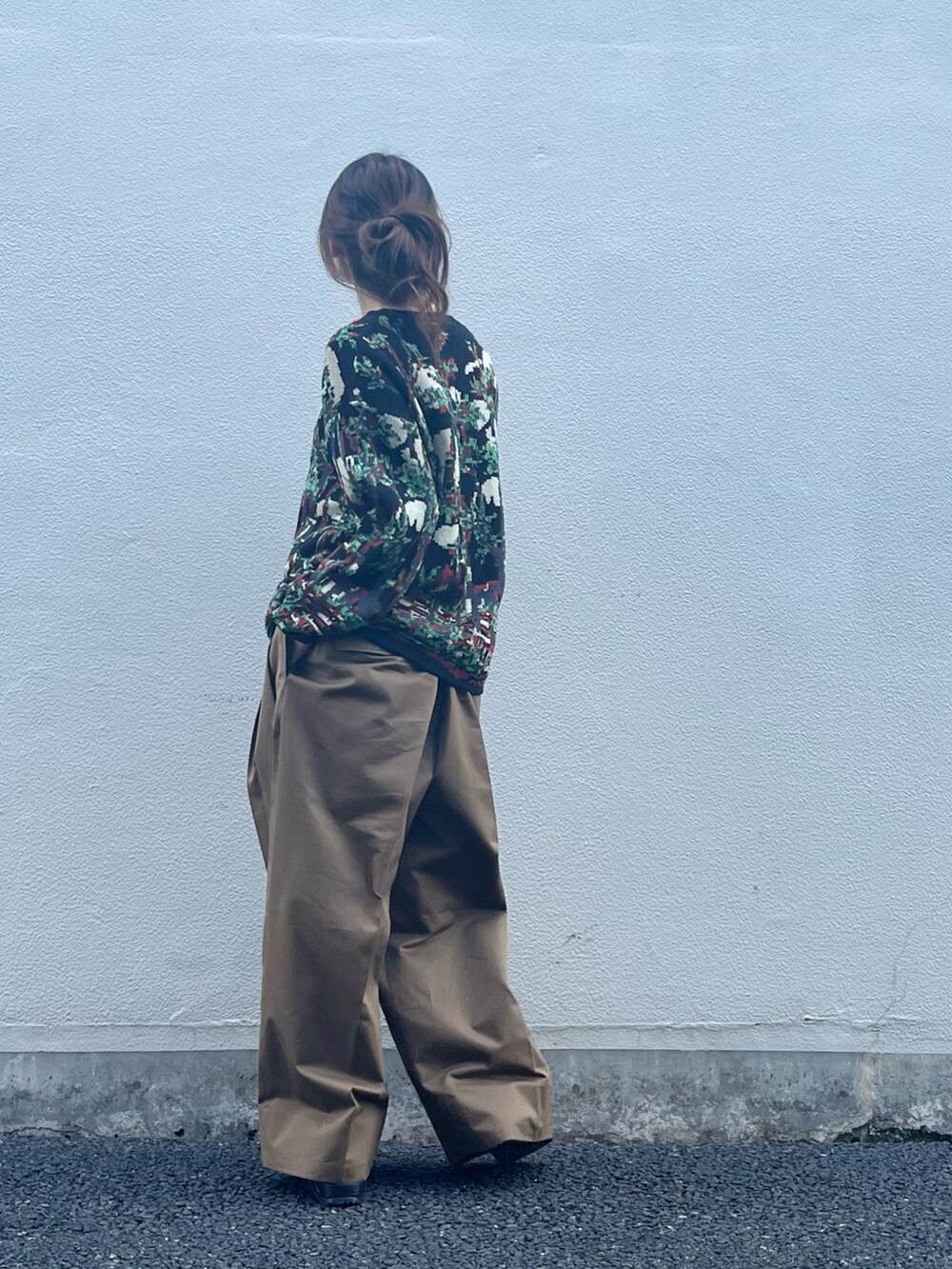 ブラック系のトップス、ブラウン系のパンツ、ブラック系のサンダルを着用したレディースの春コーディネートの3枚目の写真