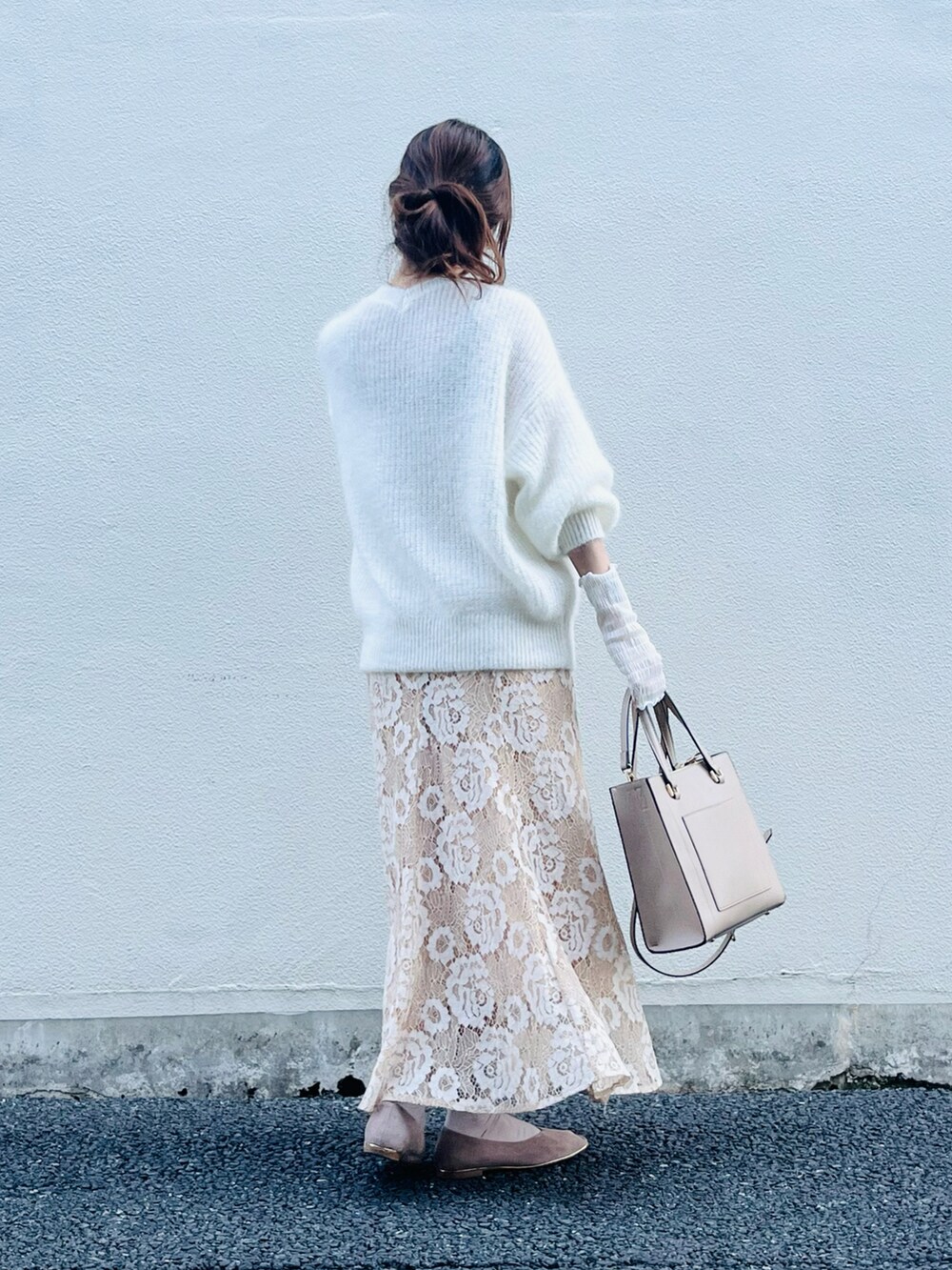 ベージュ系のスカート、ホワイト系のニット/セーター、ベージュ系のバッグを着用したレディースの春コーディネートの3枚目の写真