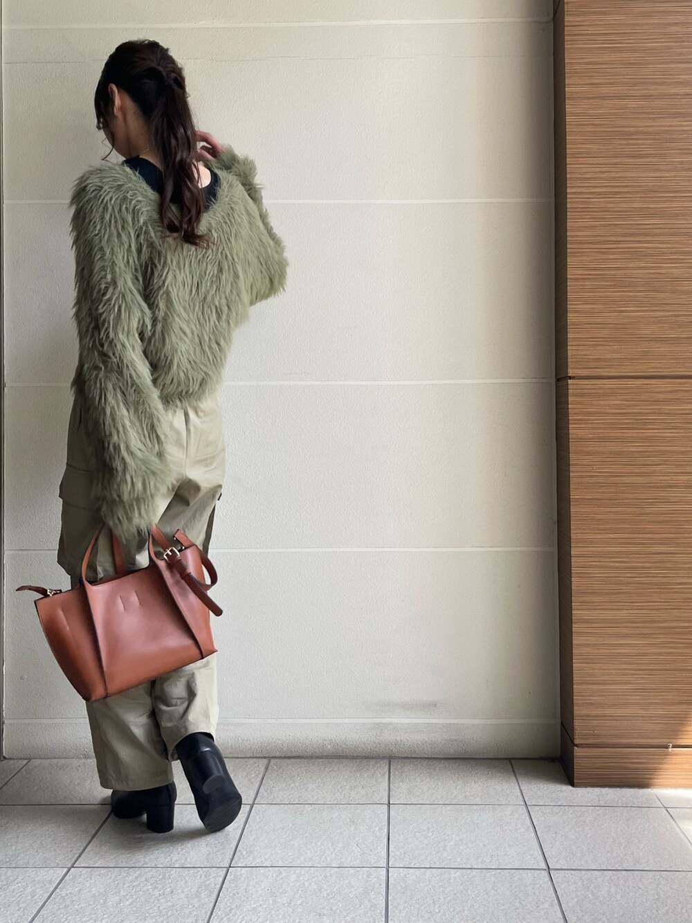 ブラック系のブーツ、ブラウン系のバッグ、グリーン系のカーディガン/ボレロを着用したレディースの秋コーディネートの4枚目の写真