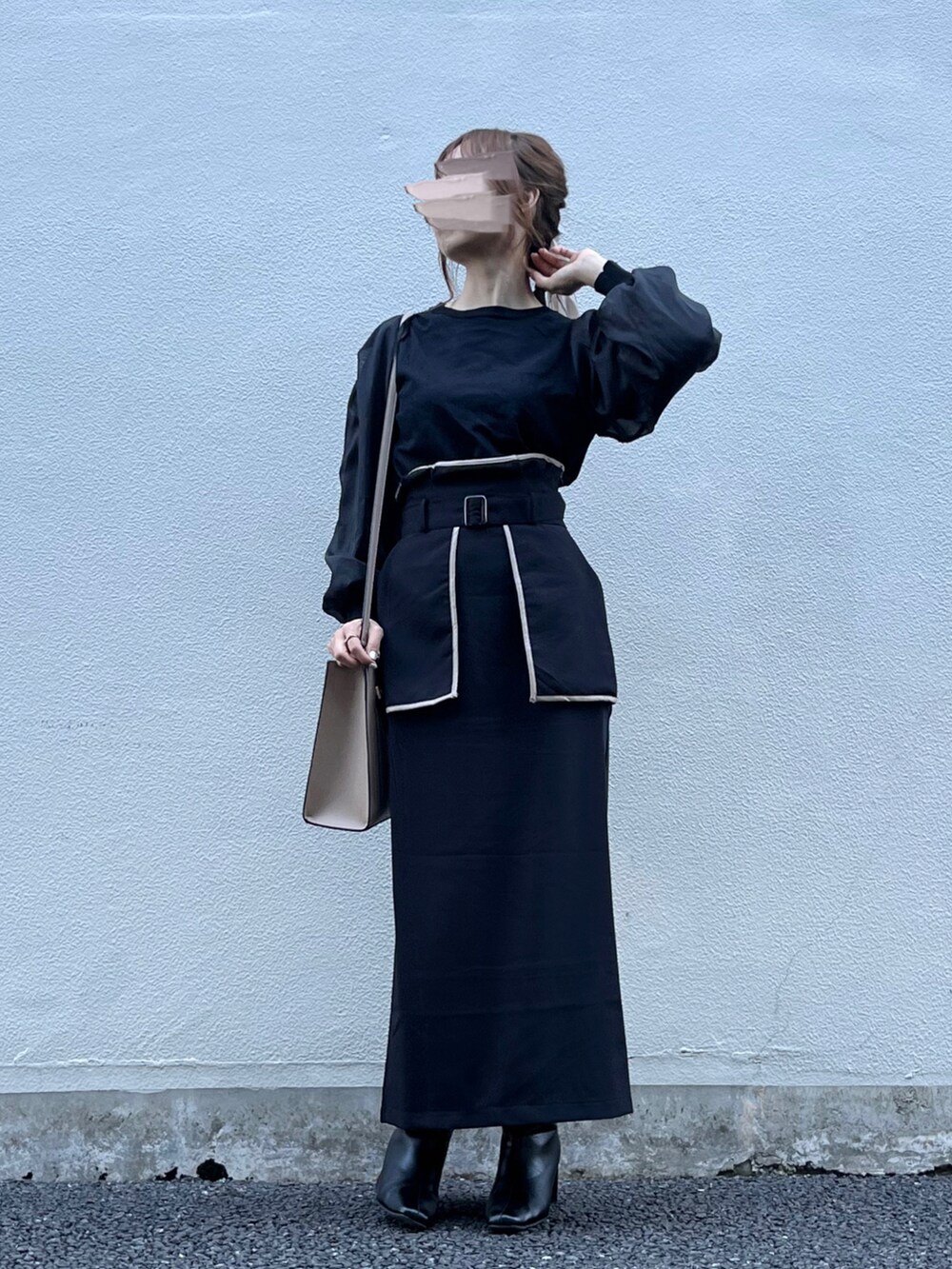 ブラック系のスカート、ベージュ系のバッグ、ブラック系のニット/セーターを着用したレディースの秋コーディネートの4枚目の写真