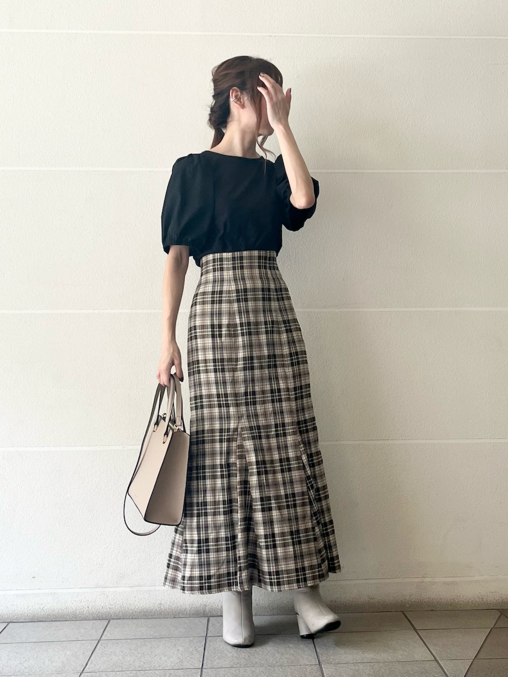 ベージュ系のスカート、ブラック系のTシャツ/カットソー、ベージュ系のバッグを着用したレディースの夏コーディネートの4枚目の写真