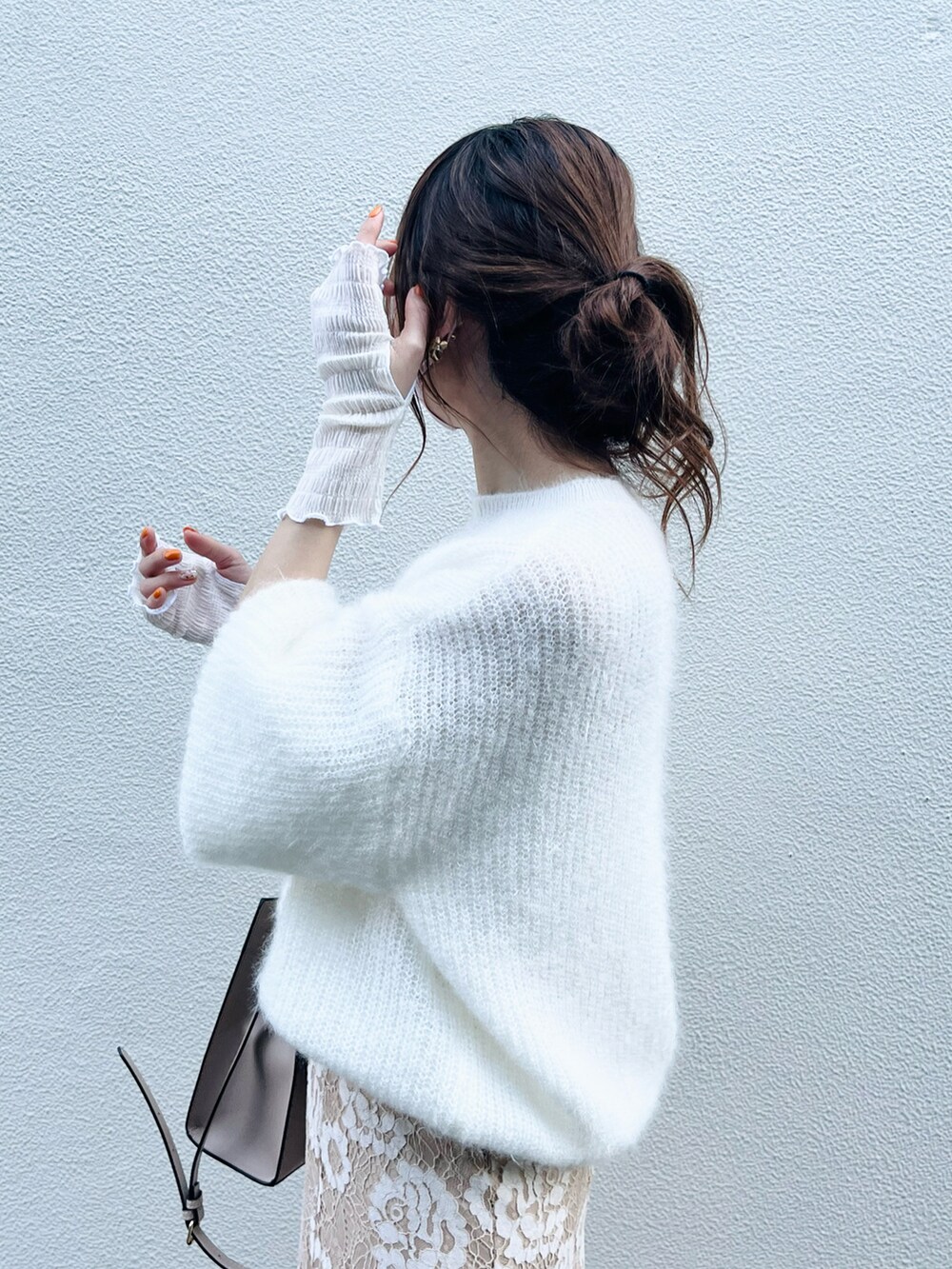 ベージュ系のスカート、ホワイト系のニット/セーター、ベージュ系のバッグを着用したレディースの春コーディネートの5枚目の写真