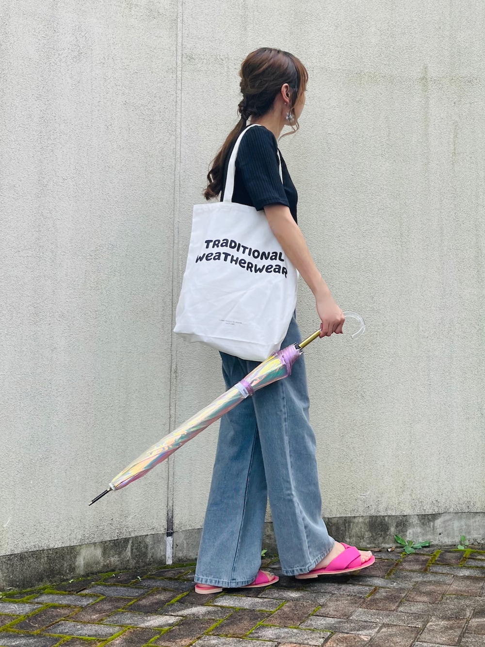 ホワイト系のトートバッグ、ピンク系のサンダル、ブラック系のTシャツ/カットソーを着用したレディースの夏コーディネートの2枚目の写真