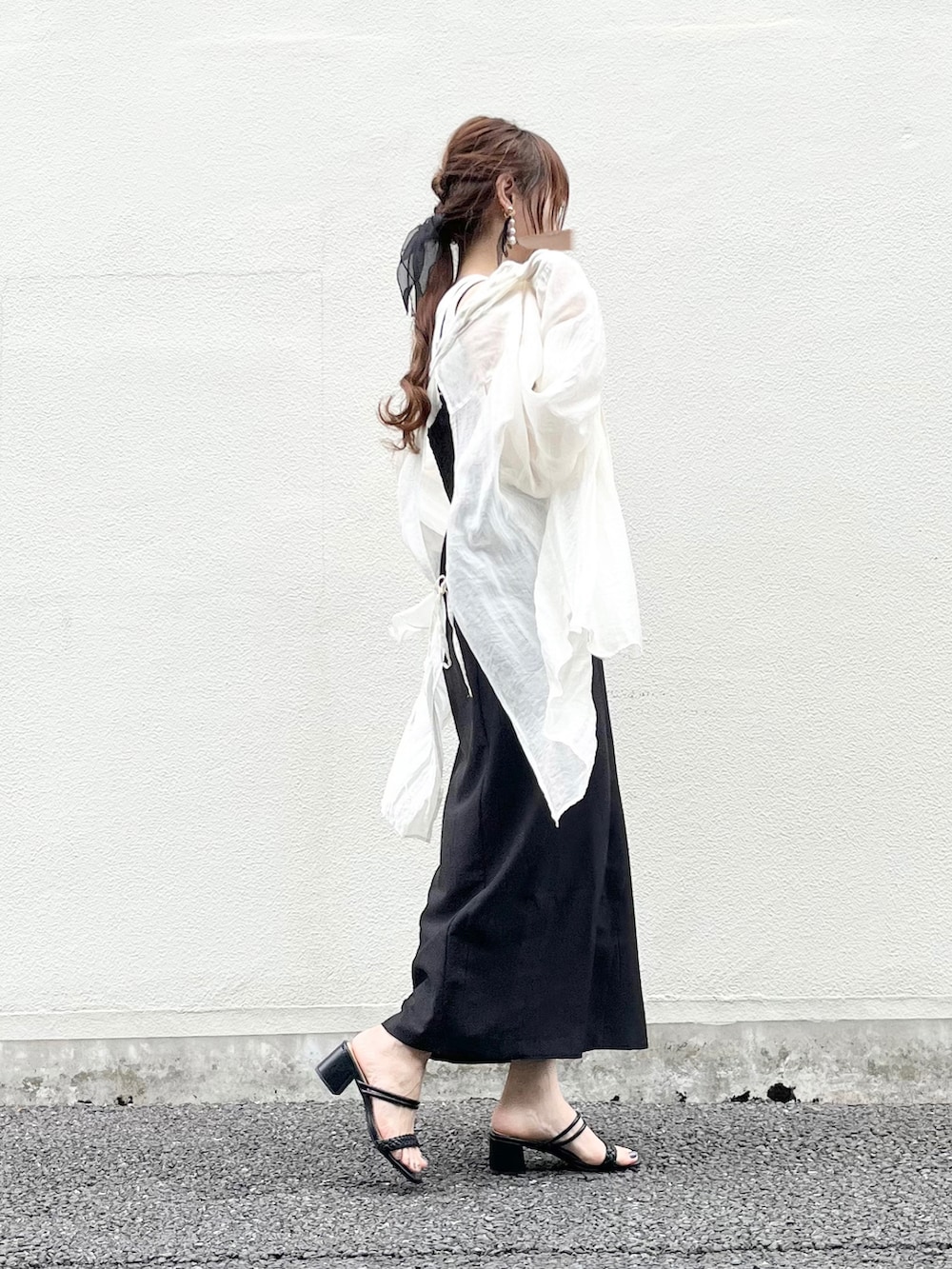 ブラック系のワンピース、ブラック系のサンダル、ホワイト系のシャツ/ブラウスを着用したレディースの春コーディネートの2枚目の写真