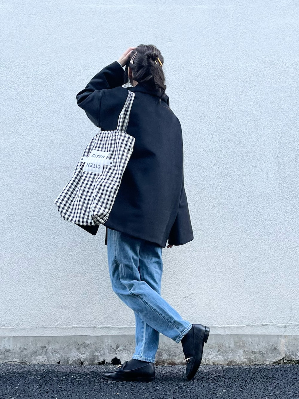 ホワイト系のTシャツ/カットソー、ブラック系のトートバッグ、ブラック系のその他アウターを着用したレディースの冬コーディネートの3枚目の写真