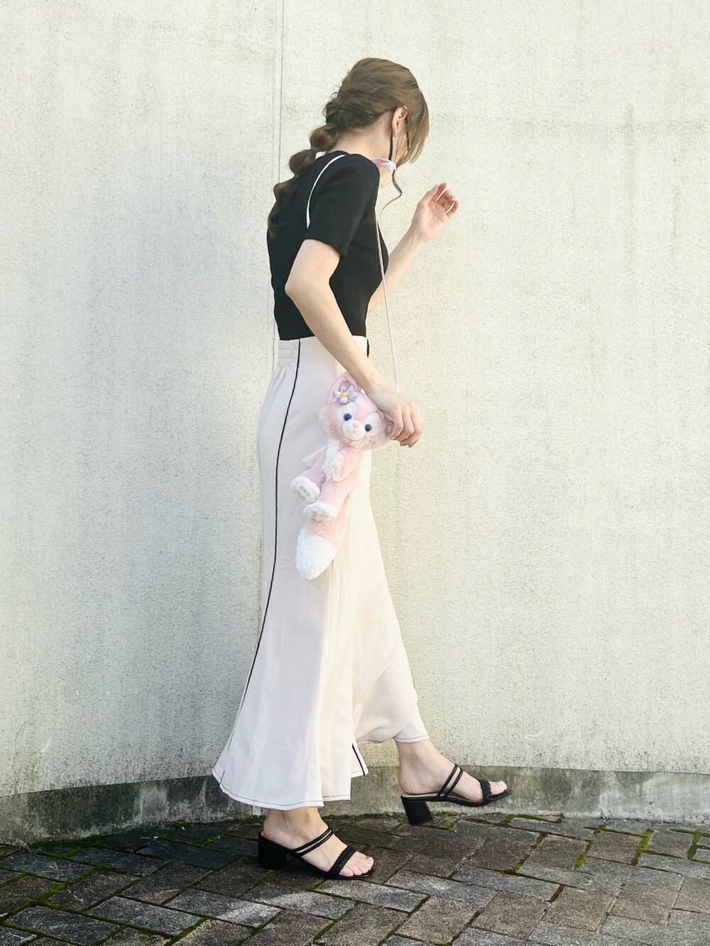 ブラック系のニット/セーター、ベージュ系のスカート、ブラック系のサンダルを着用したレディースの夏コーディネートの4枚目の写真