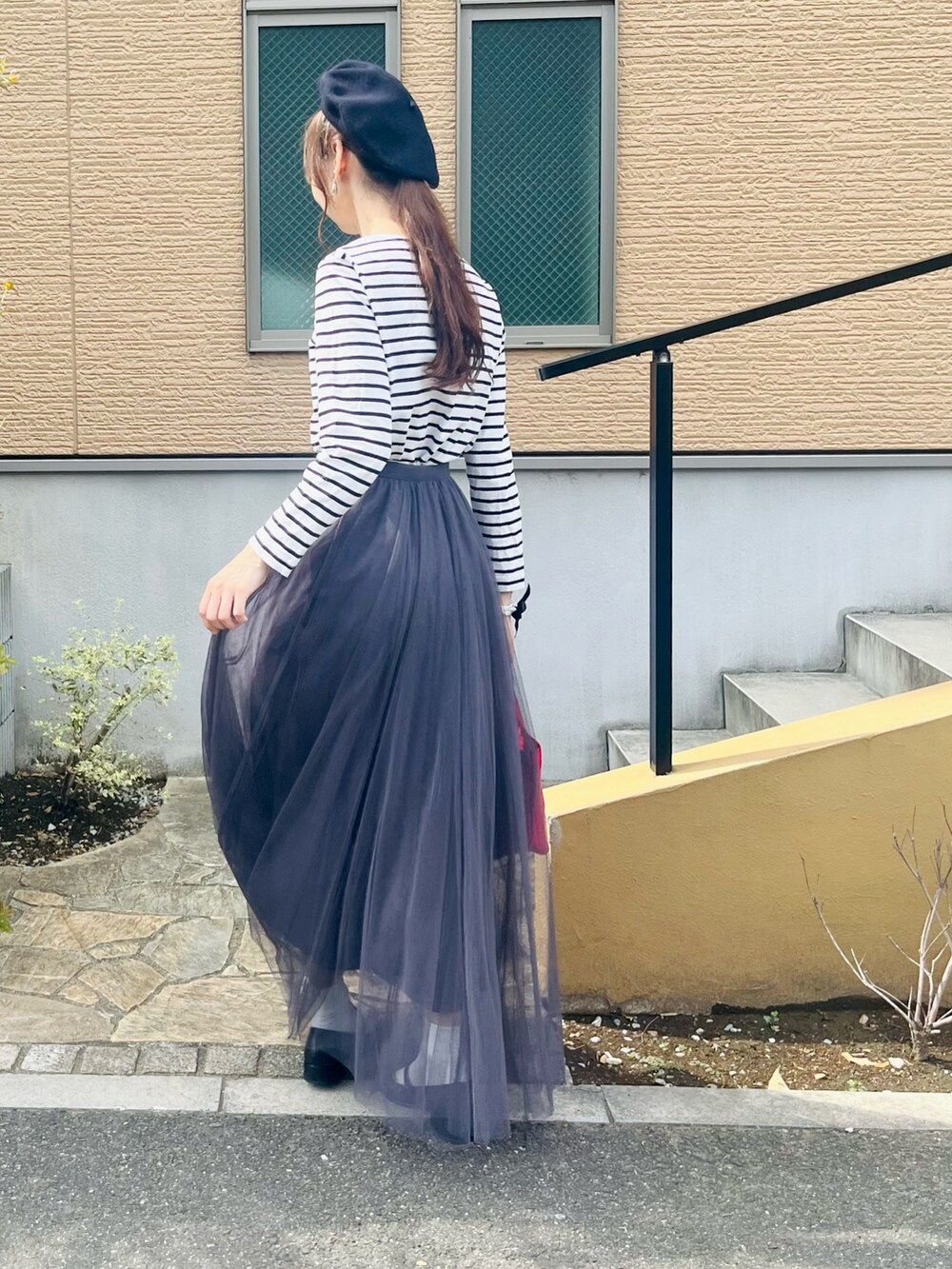 ブラック系のパンプス、グレー系のスカート、ホワイト系のTシャツ/カットソーを着用したレディースの秋コーディネートの4枚目の写真