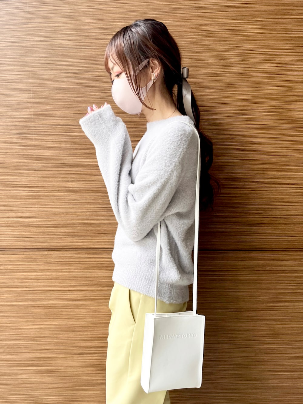 ホワイト系のブルゾン、ホワイト系のショルダーバッグ、イエロー系のその他パンツを着用したレディースの冬コーディネートの4枚目の写真