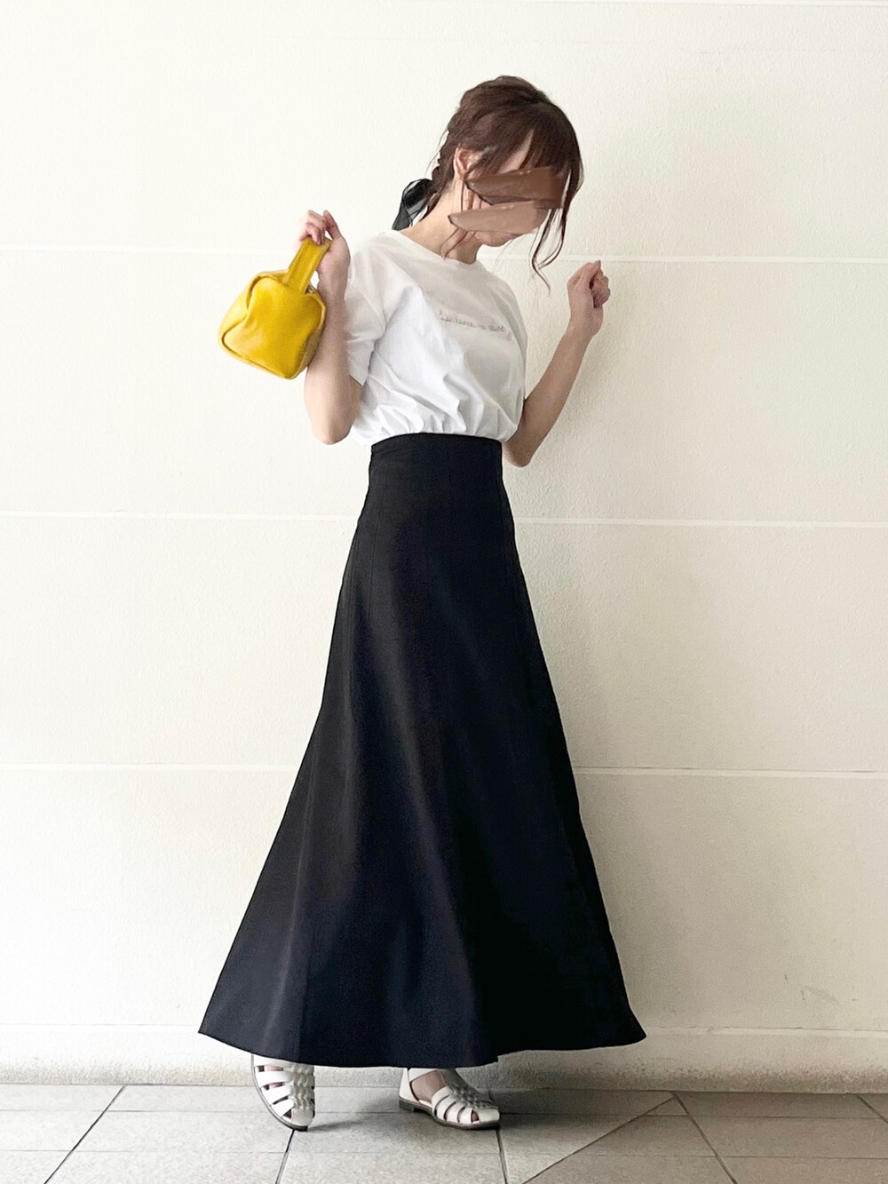 ホワイト系のTシャツ/カットソー、イエロー系のハンドバッグ、ブラック系のスカートを着用したレディースの春コーディネートの3枚目の写真