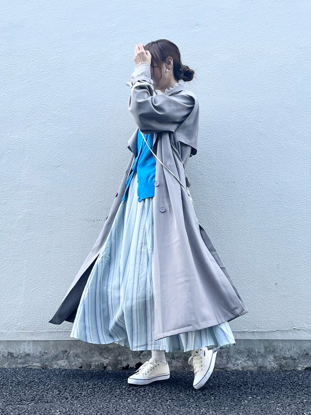 シルバー系のショルダーバッグ、グレー系のトレンチコート、ブルー系のカーディガン/ボレロを着用したレディースの春コーディネートの2枚目の写真