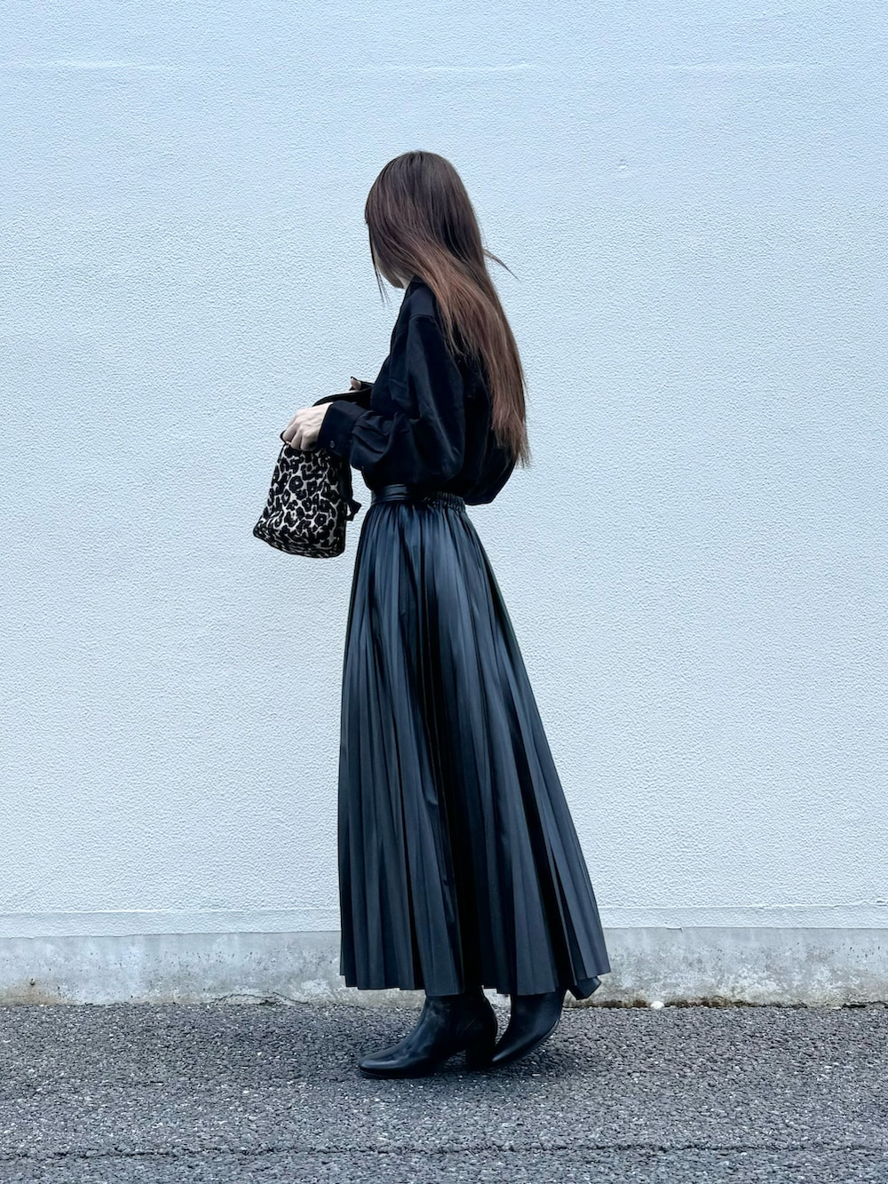 ブラック系のブーツ、ブラウン系のハンドバッグ、ブラック系のシャツ/ブラウスを着用したレディースの秋コーディネートの2枚目の写真