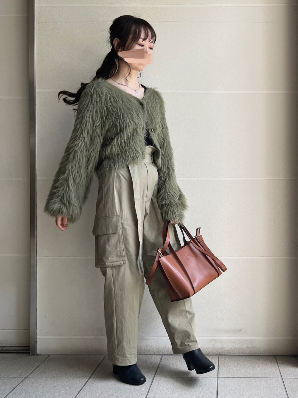 ブラック系のブーツ、ブラウン系のバッグ、グリーン系のカーディガン/ボレロを着用したレディースの秋コーディネートの2枚目の写真