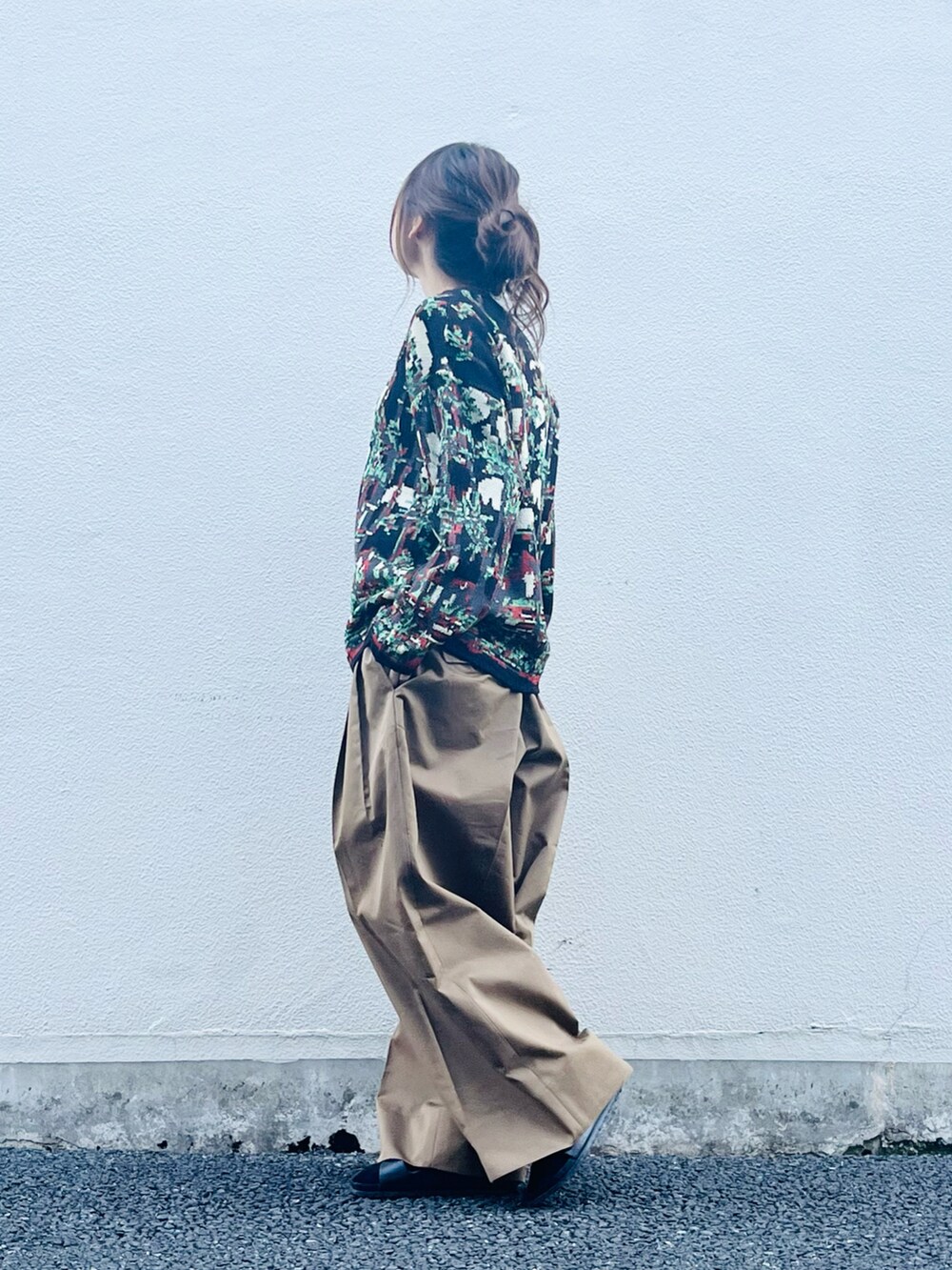 ブラック系のトップス、ブラウン系のパンツ、ブラック系のサンダルを着用したレディースの春コーディネートの5枚目の写真