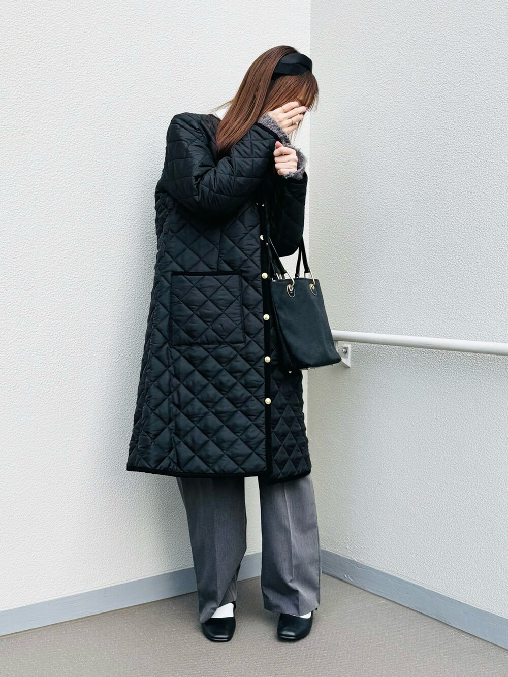ブラック系のパンプス、ブラック系のその他アウター、ブラック系のバッグを着用したレディースの冬コーディネートの2枚目の写真