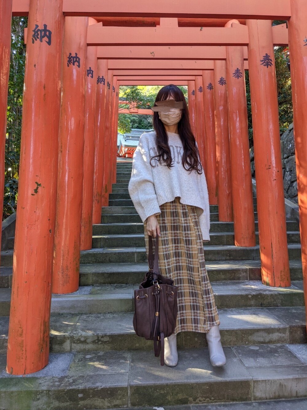 ホワイト系のニット/セーター、イエロー系のスカート、ホワイト系のブーツを着用したレディースの冬コーディネートの2枚目の写真