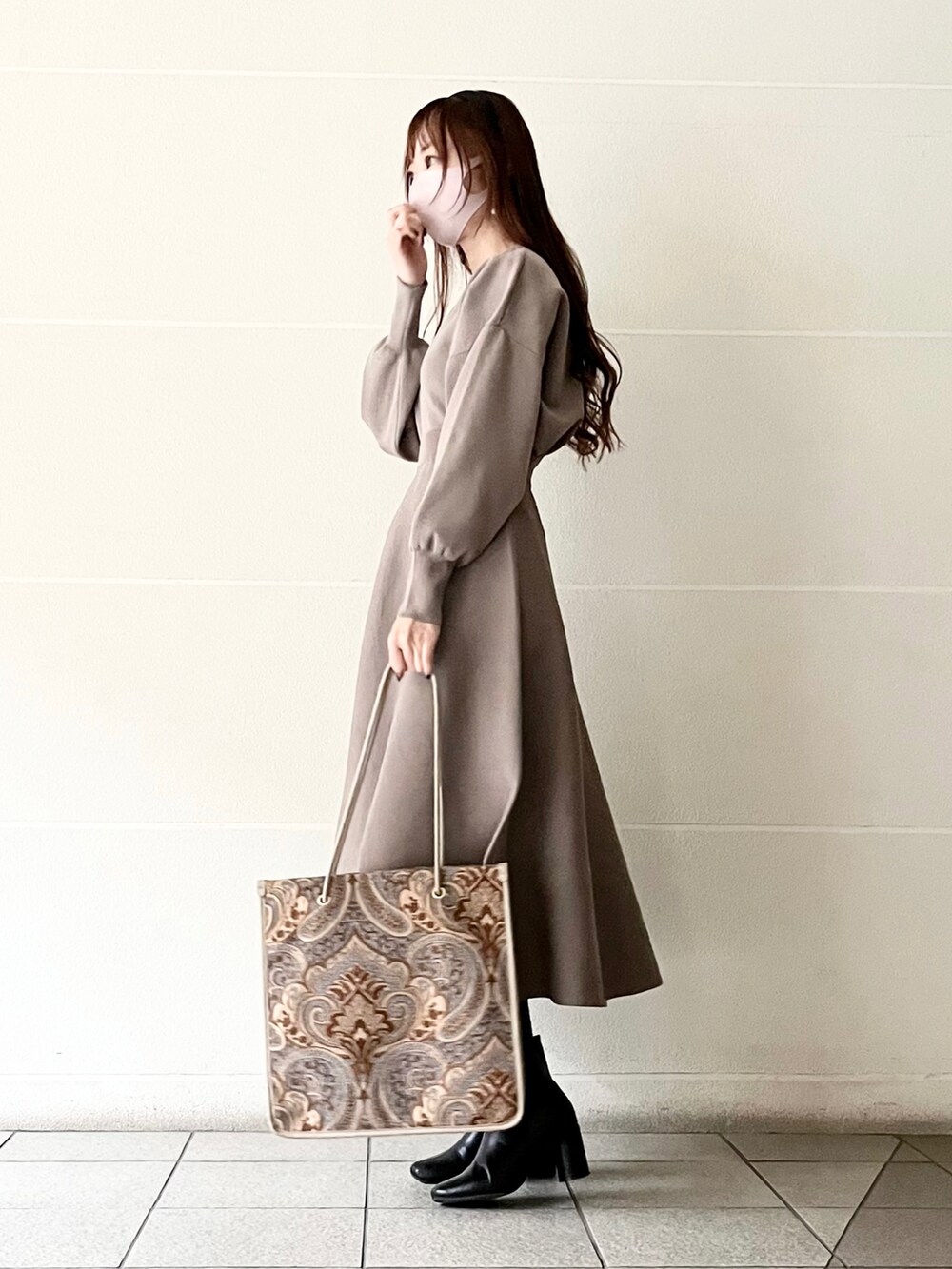 ブルー系のトートバッグ、ブラウン系のニット/セーター、ブラウン系のスカートを着用したレディースの冬コーディネートの3枚目の写真