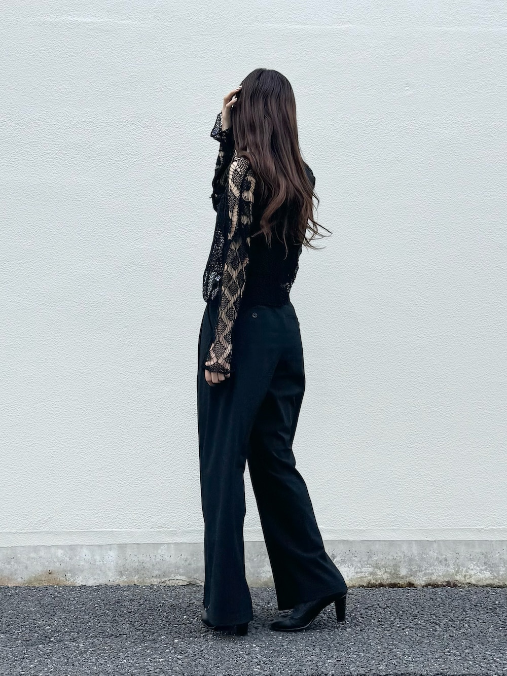 ブラック系のニット/セーター、ブラック系のパンツ、ブラック系のタンクトップを着用したレディースの秋コーディネートの5枚目の写真