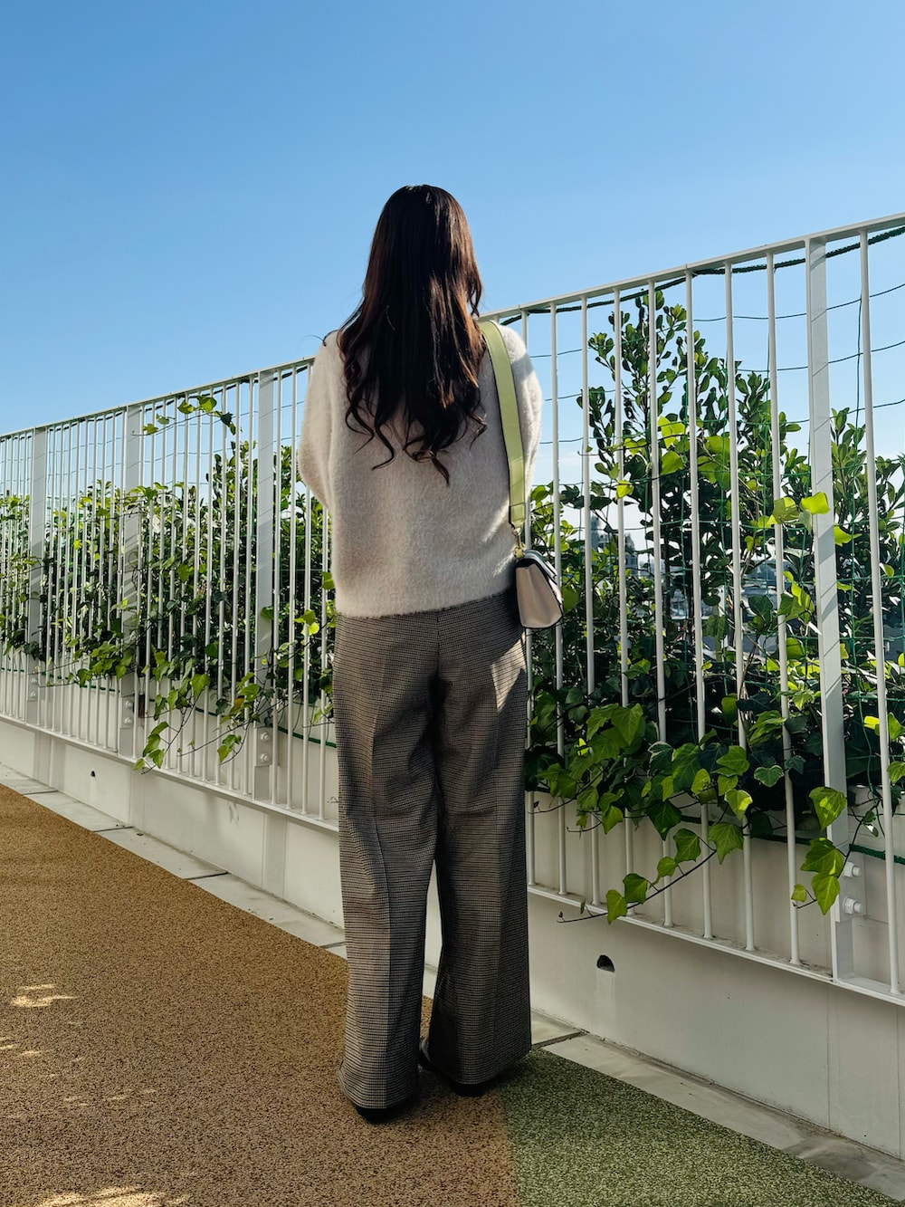 ピンク系のハンドバッグ、ブラック系のブーツ、ベージュ系のカーディガン/ボレロを着用したレディースの秋コーディネートの5枚目の写真